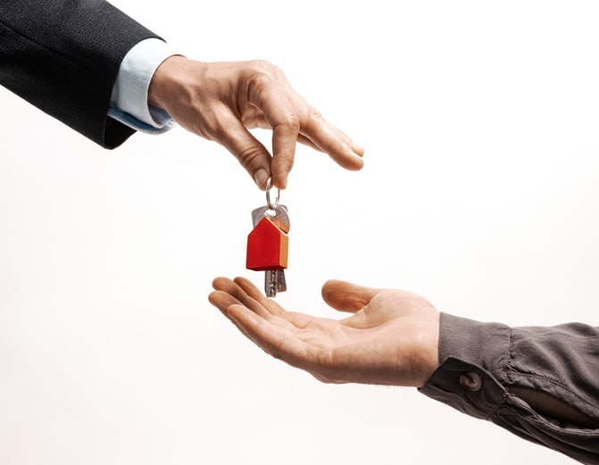 The real estate agent hands over the keys to the property to the new owner.